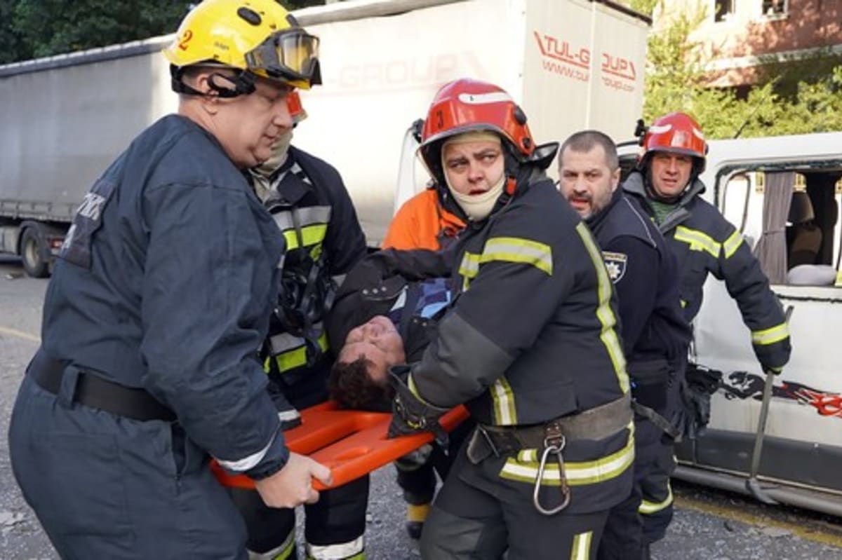 Hasiči i záchranáři se snažili pomoci lidem poté, co Rusko Kyjev ostřelovalo raketami.
