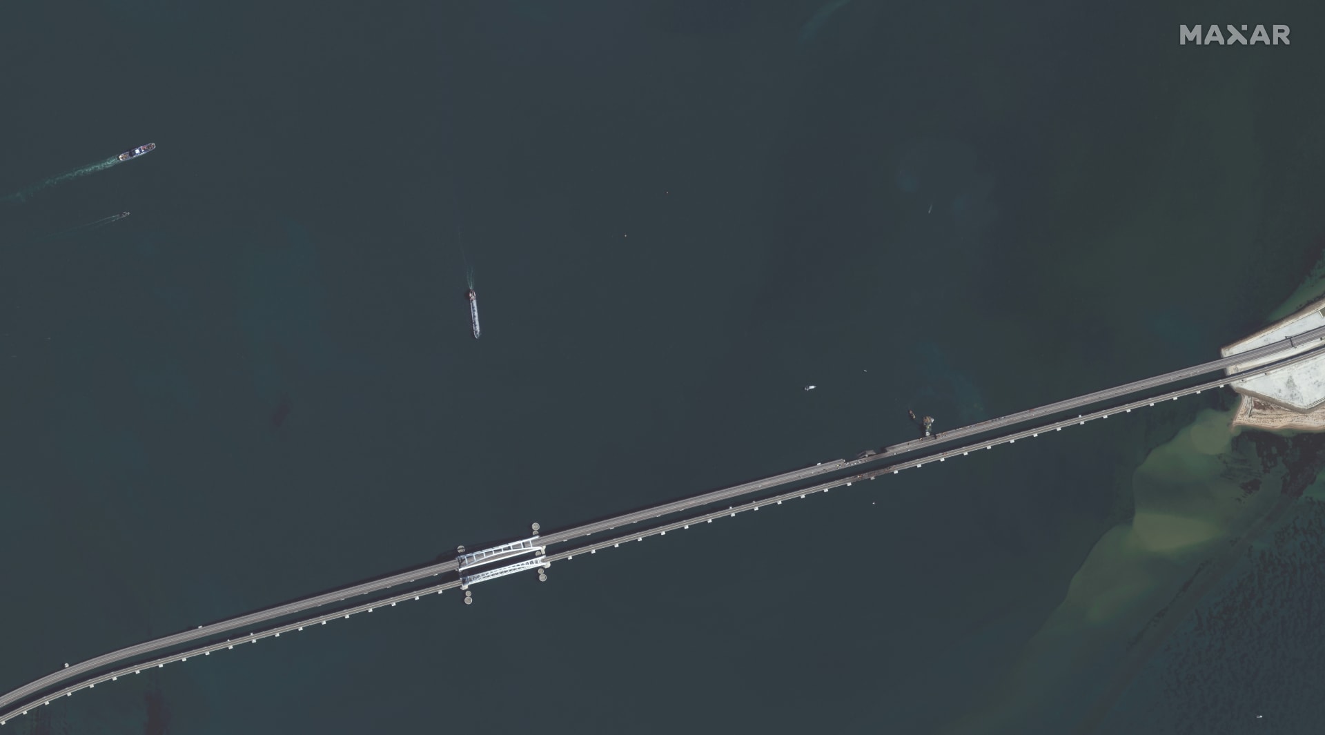 Satelitní snímky americké společnosti Maxar Technologies ukazují opravy a dopravu na Kerčském mostě (12.10.2022).