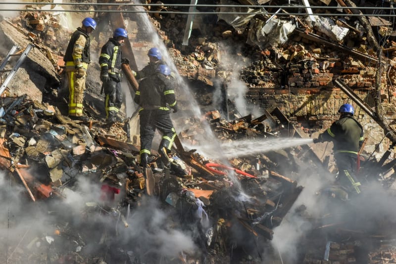 Ukrajinští záchranáři zasahují v troskách domu, který poničil úder ruských dronů. (17. 10. 2022)