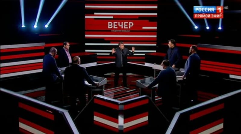 Televizní studio kanálu Rossija 1, uprostřed stojí moderátor a známý prokremelský propagandista Vladimir Solovjov.