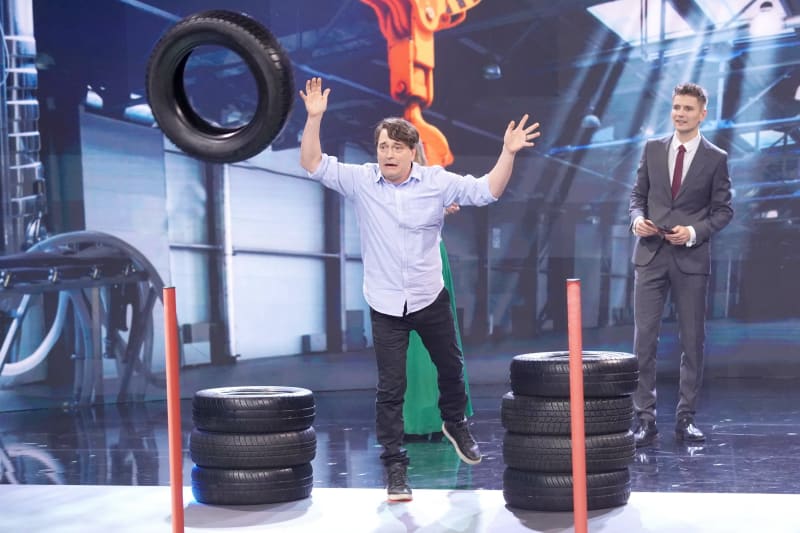 Saša Rašilov soutěží v hodu pneumatikou.