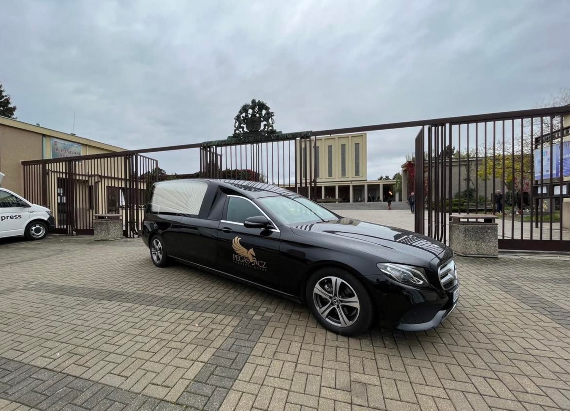 Před vchodem do strašnického krematoria stojí pohřební vůz s rakví Josefa Somra