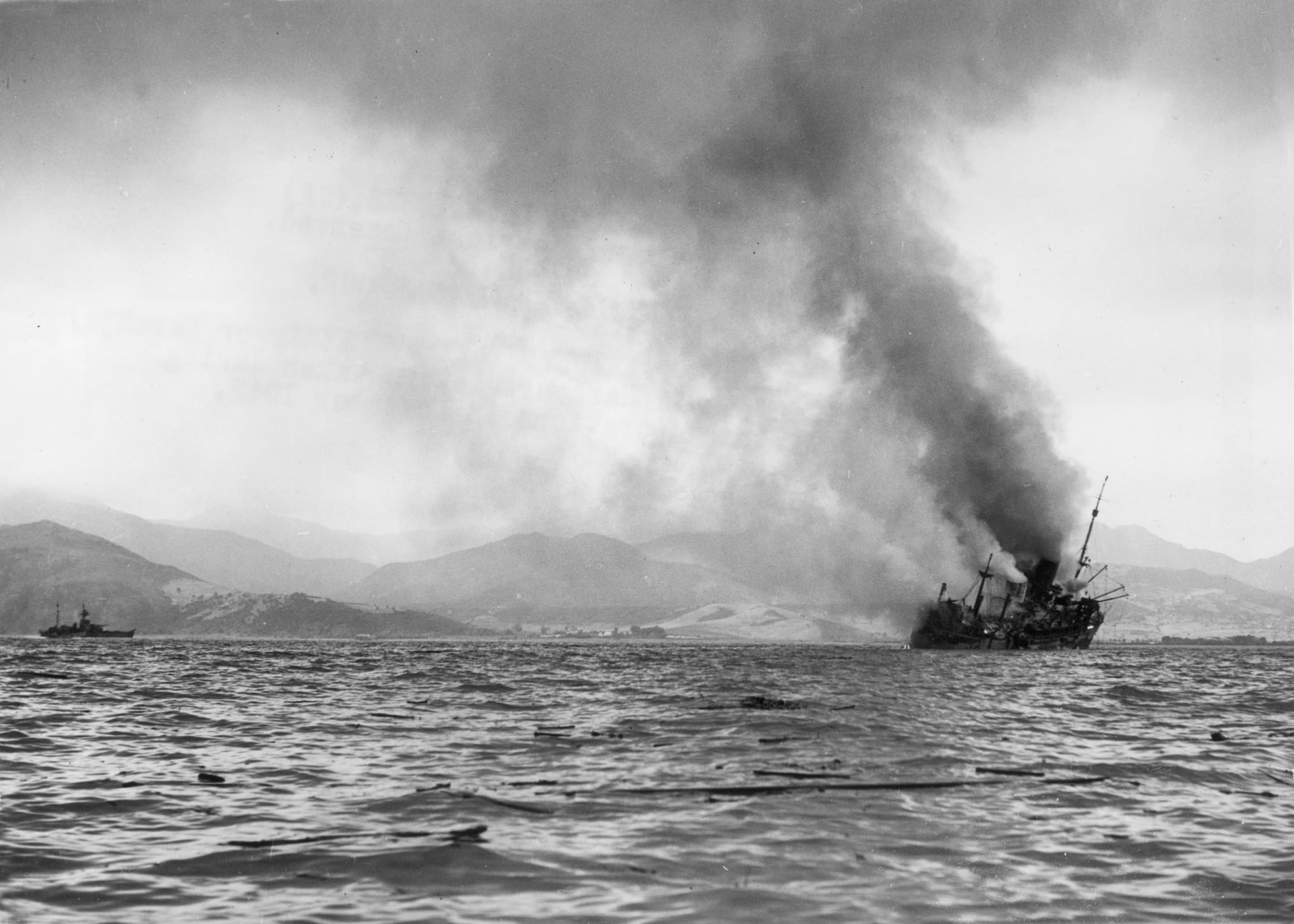 Britská loď (zřejmě Cathay nebo Karanja) hoří poblíž přístavu Bidžája