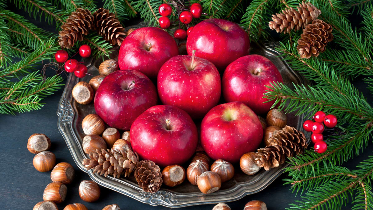 Pár jablek a ořechů a ánoční dekorace na stůl je připravená