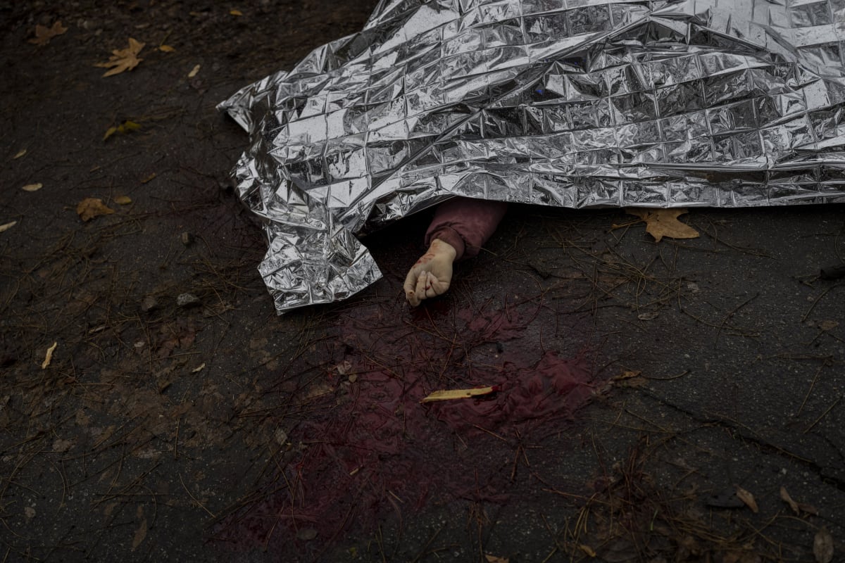 Plachta přikrývá tělo ženy, která zemřela při ruském ostřelování Chersonu