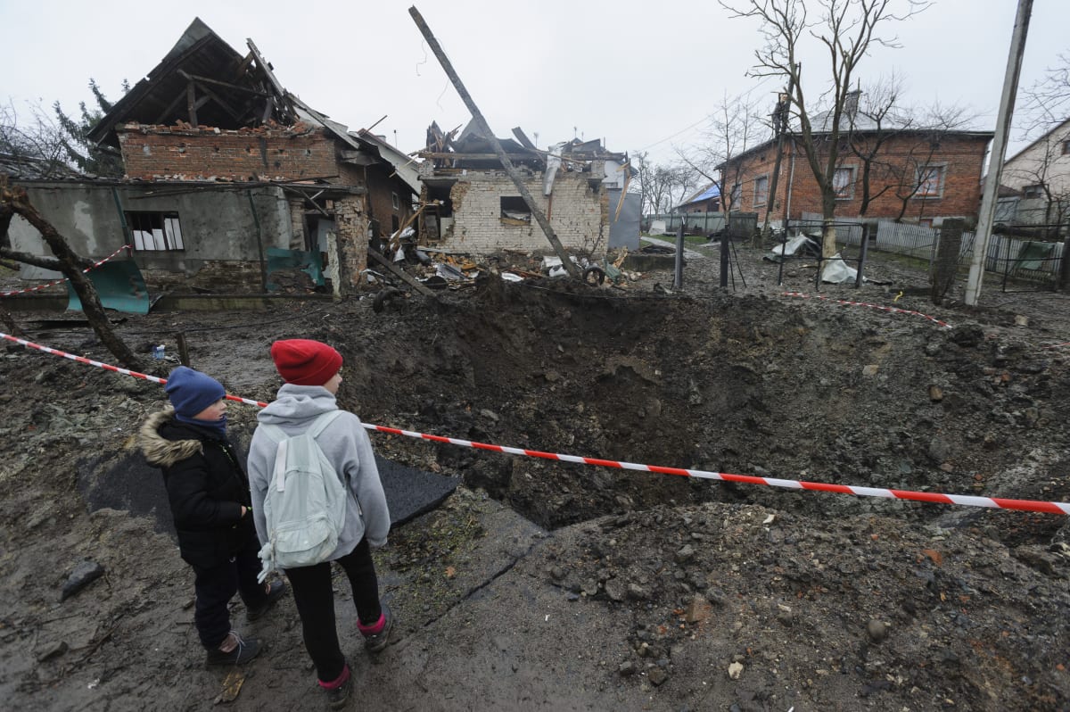 Děti obhlížejí kráter po ruském ostřelování města Solonka ve Lvovské oblasti