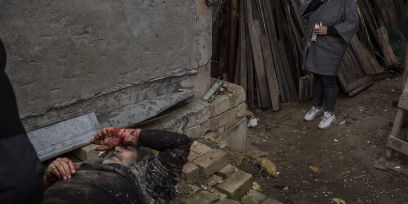 Žena pláče při pohledu na zraněného manžela po ruském útoku na město Cherson
