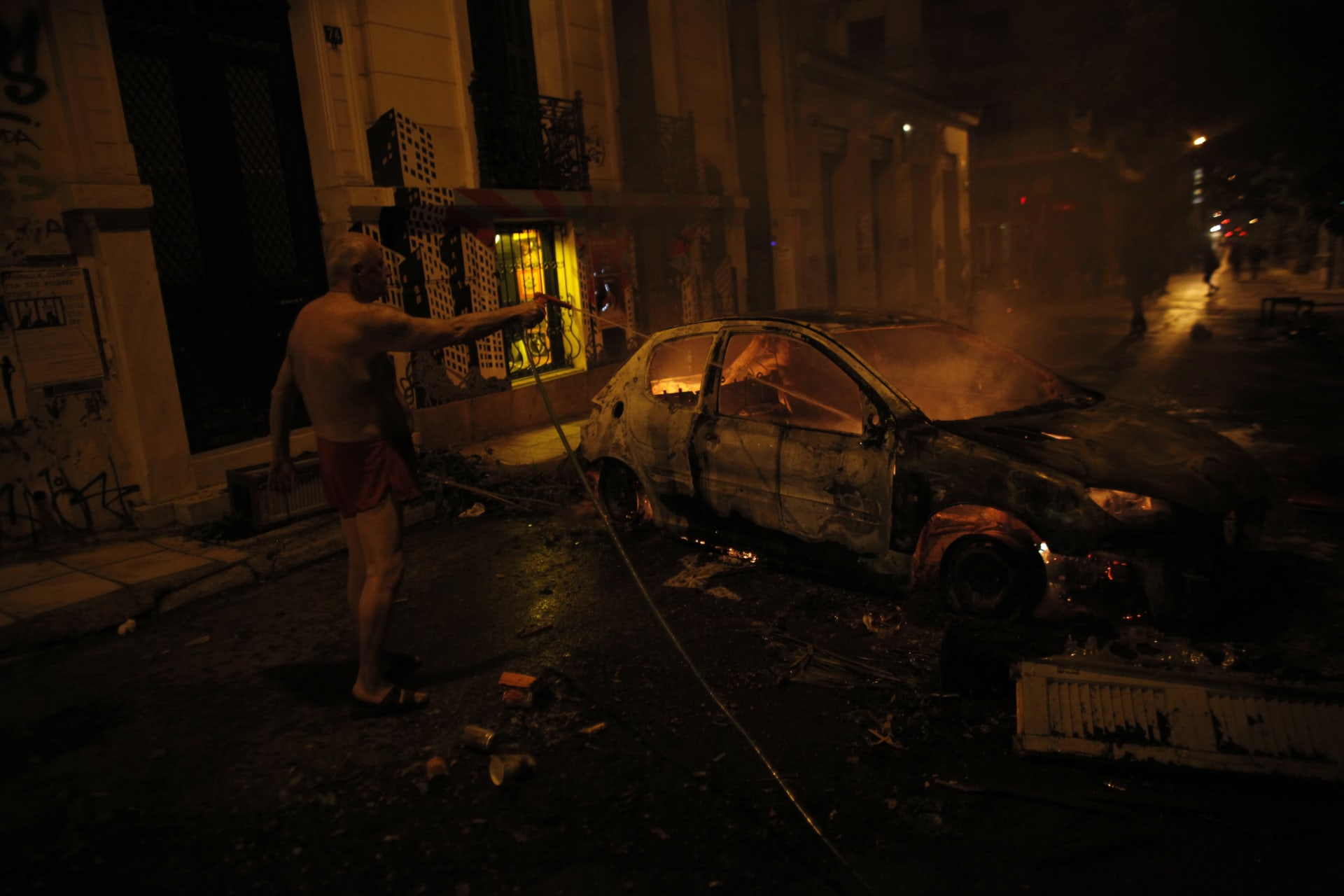Muž ve spodním prádle hasí hořící auto (6.12.2014).