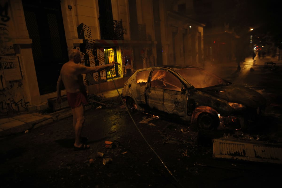 Muž ve spodním prádle hasí hořící auto (6.12.2014).