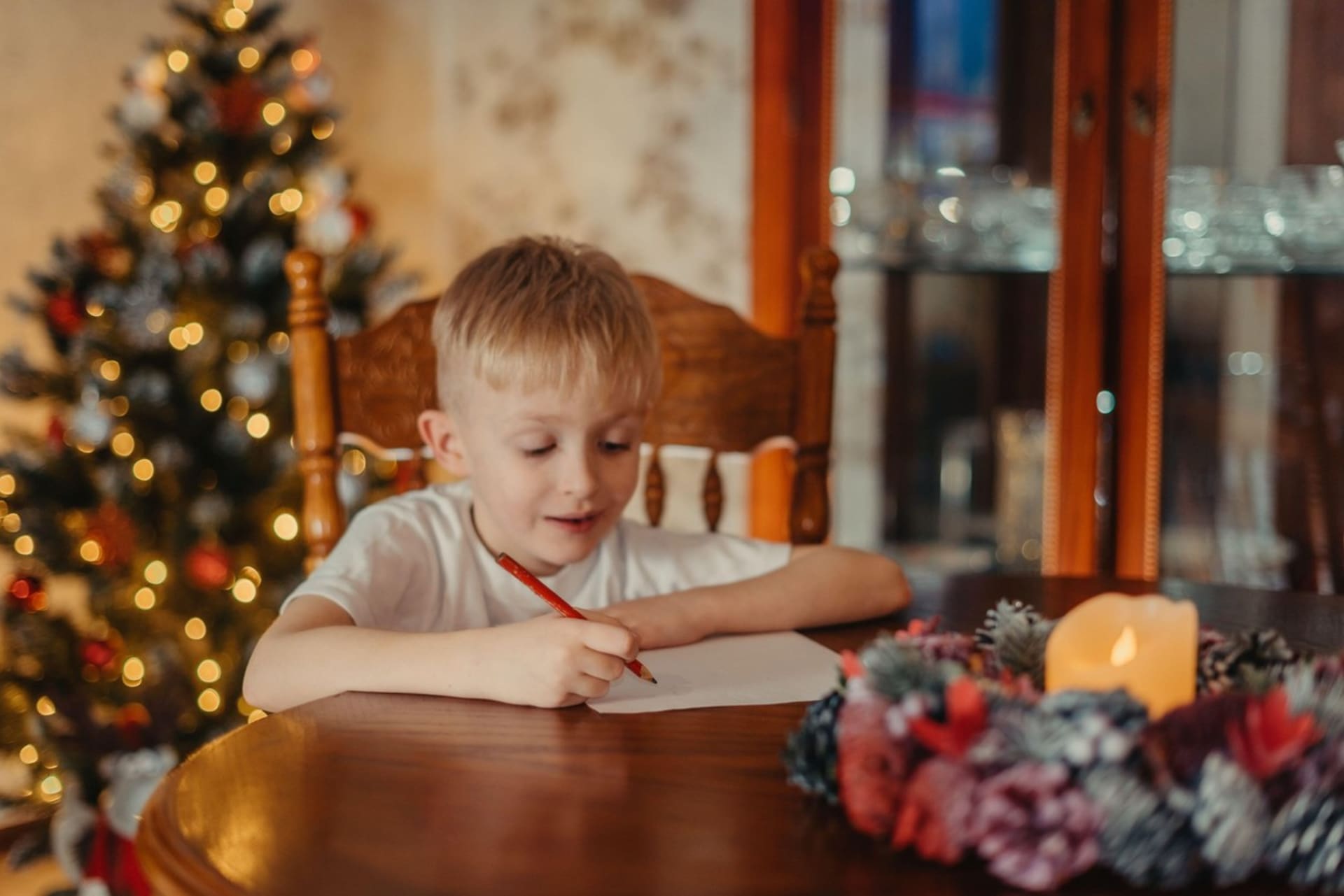 Chlapec píše svá přání k Vánocům