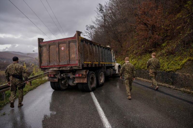 Vojáci NATO v Kosovu obhlížejí silniční blokádu.