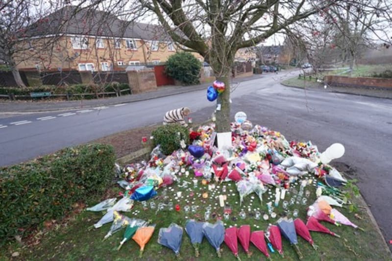 Lidé nosí květiny a svíce nedaleko místa tragédie. 