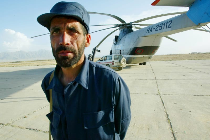 Afghánský strážný hlídá ruský Mi-26 na letišti v Bagrámu, odkud se stroj vydal zachránit poškozený americký vrtulník Chinook (2002)