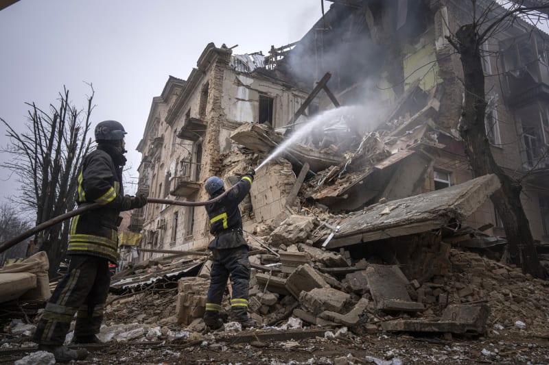Hasiči ukrajinské státní záchranné služby pracují na likvidaci požáru budovy, která byla zničena ruským útokem na město Kryvyi Rih. (16.12.2022)