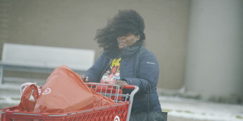  Nakupující na poslední chvíli reagují na silný nárazový vítr a mrazivé teploty zimní bouře, která zasáhla většinu USA, ve městě Flint ve státě Michigan 23. prosince 2022.