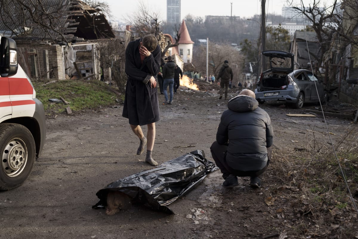 Muž pláče vedle těla své ženy, která zemřela během ruského útoku na Kyjev