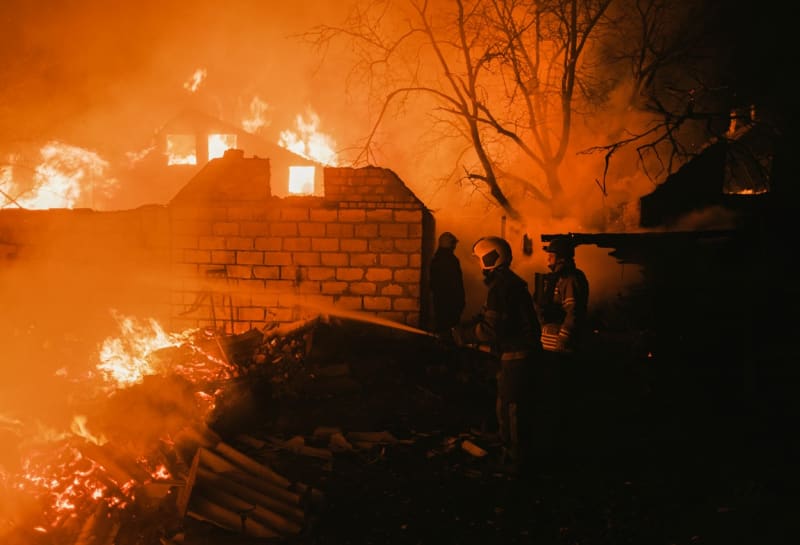 Hasiči likvidují požár domu po ruském ostřelování obce Ivanivka nedaleko Bachmutu