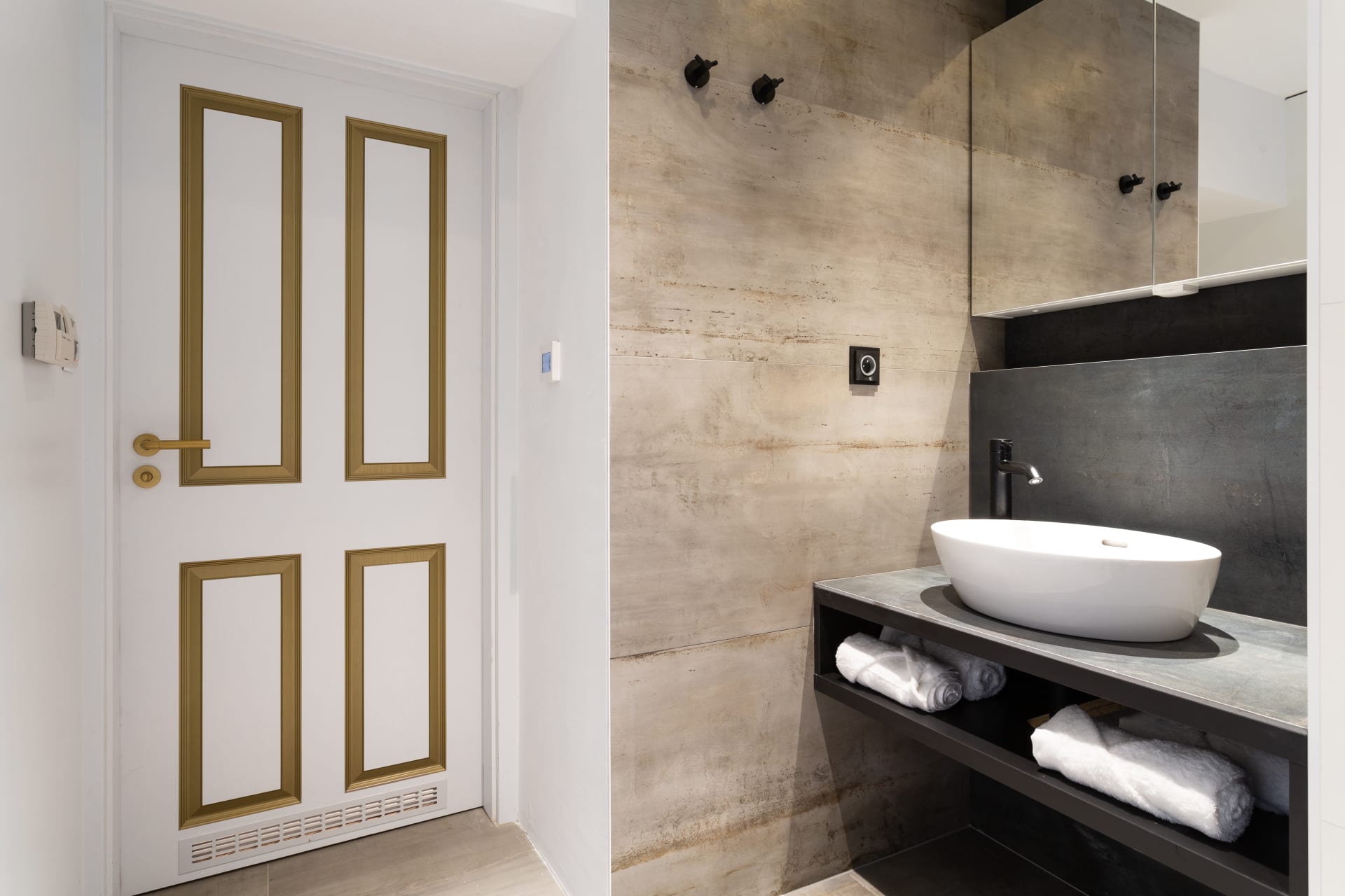 Jak se staví sen: Koupelna zaznamenala více změn. Ta je zcela přepracovaná, je laděna do bílých, šedých a černých odstínů v kombinaci s černými a zlatými doplňky.