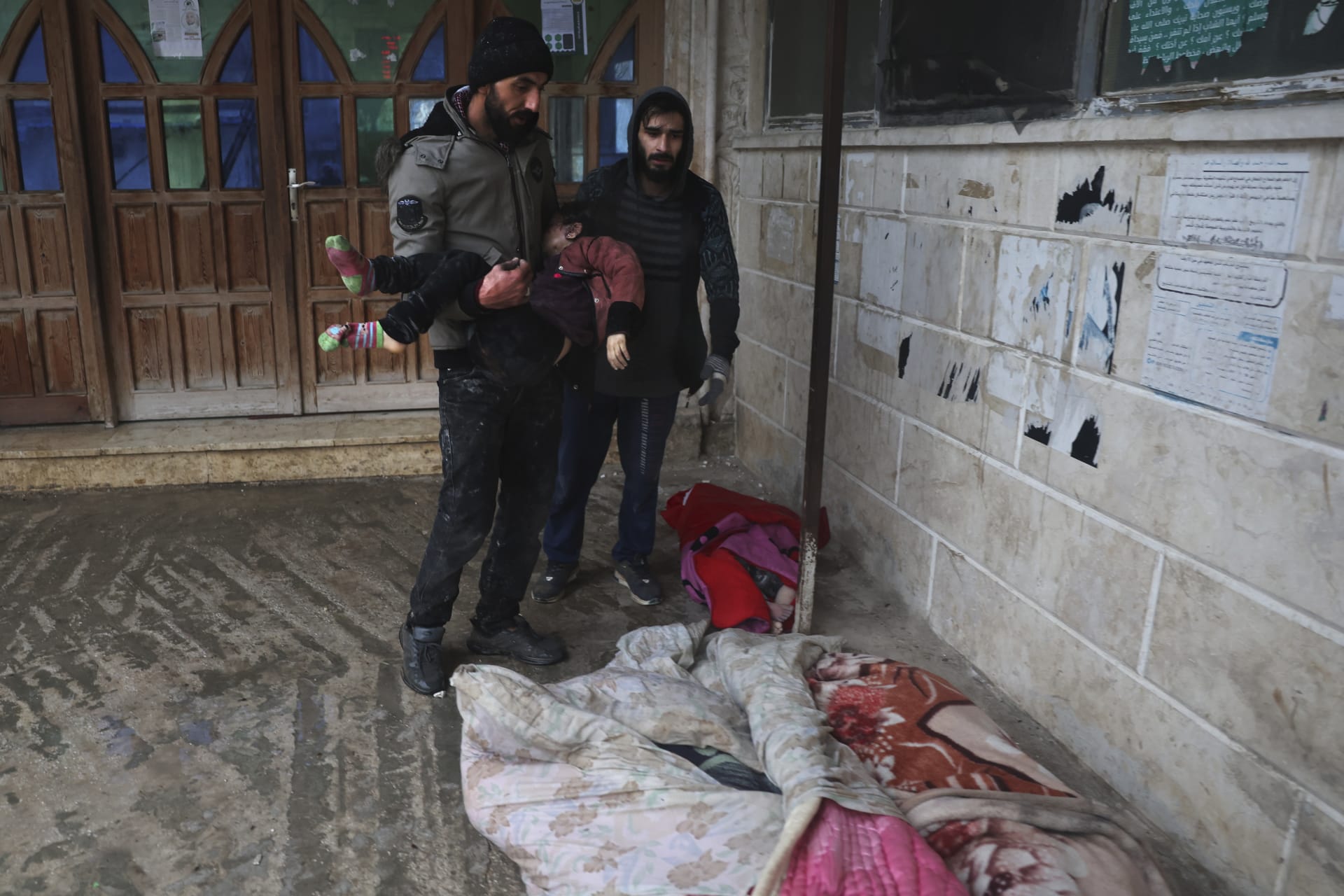 Muž v jedné ze zasažených syrských oblastí nese bezvládné tělo malé dívky (6.2.2023).