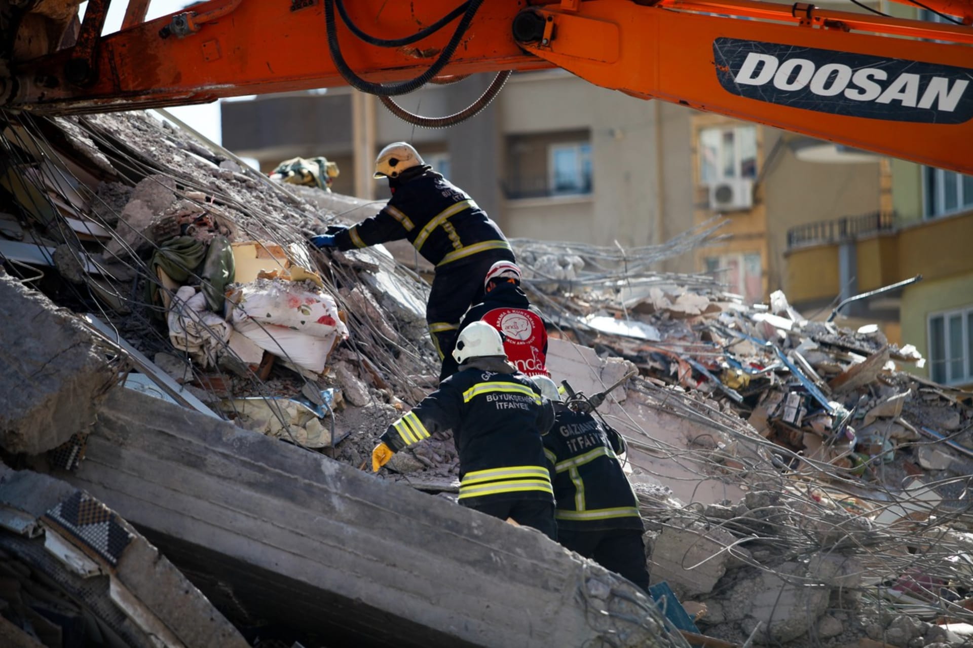 Hasiči v Turecku podnikají záchranné práce, kdy hledají lidi v sutinách domů po zemětřesení.