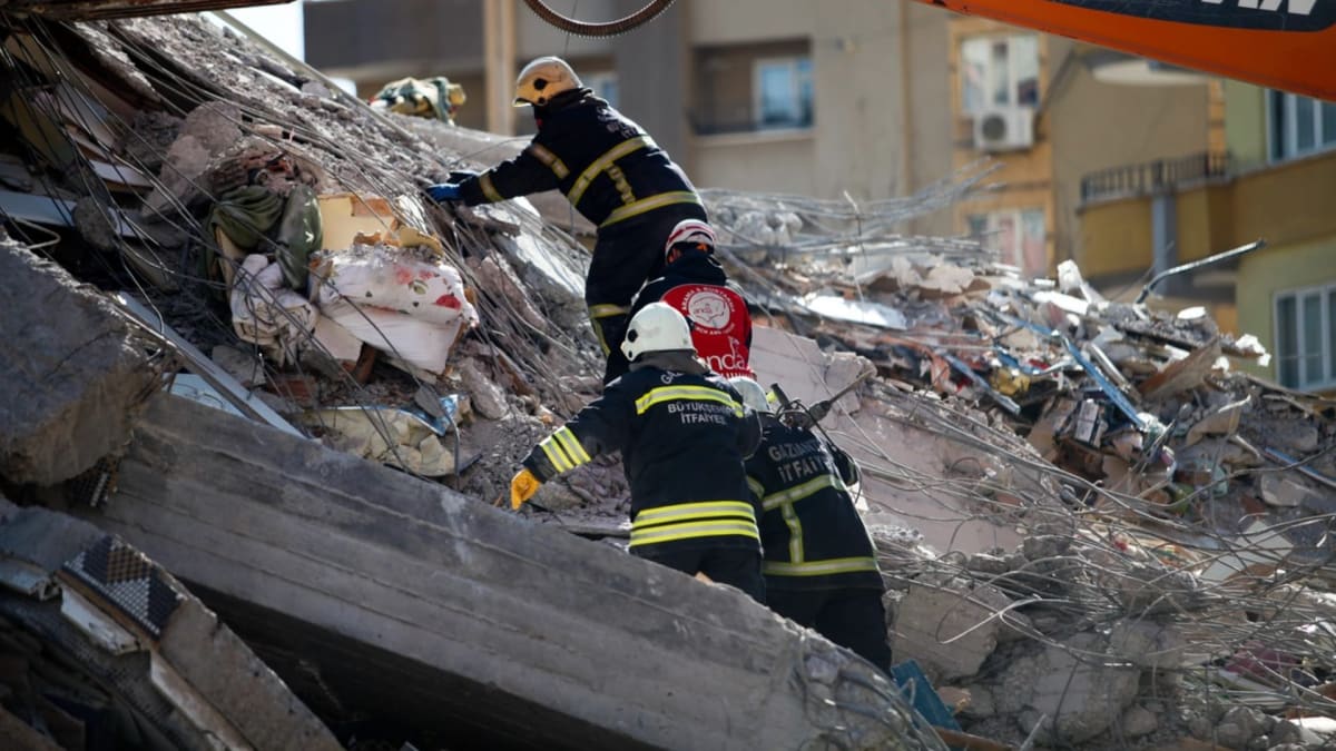 Hasiči v Turecku podnikají záchranné práce, kdy hledají lidi v sutinách domů po zemětřesení.