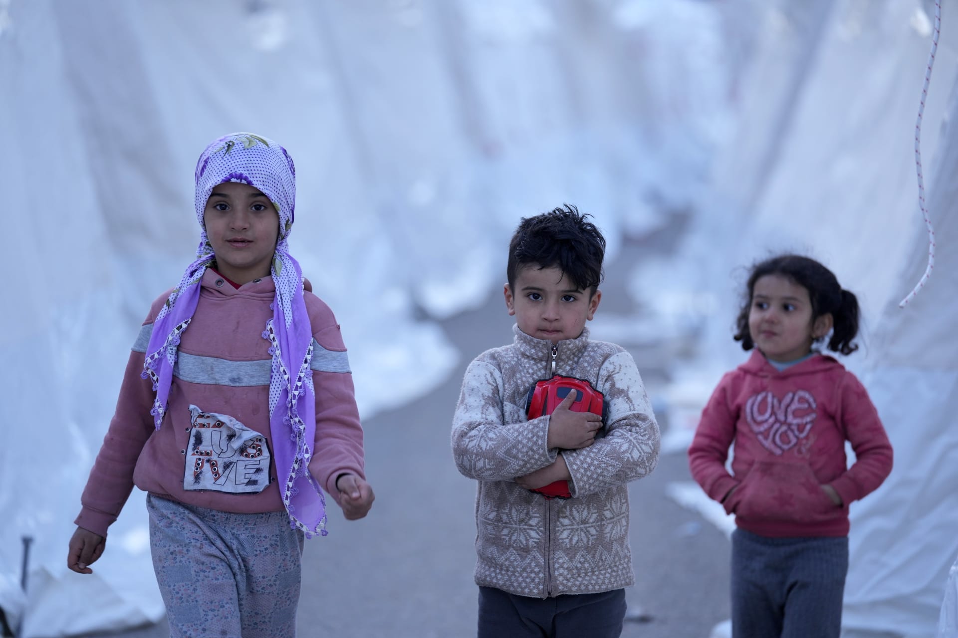 Děti procházejí mezi stany v Aslanli na jihovýchodě Turecka, čtvrtek 9. února 2023. 