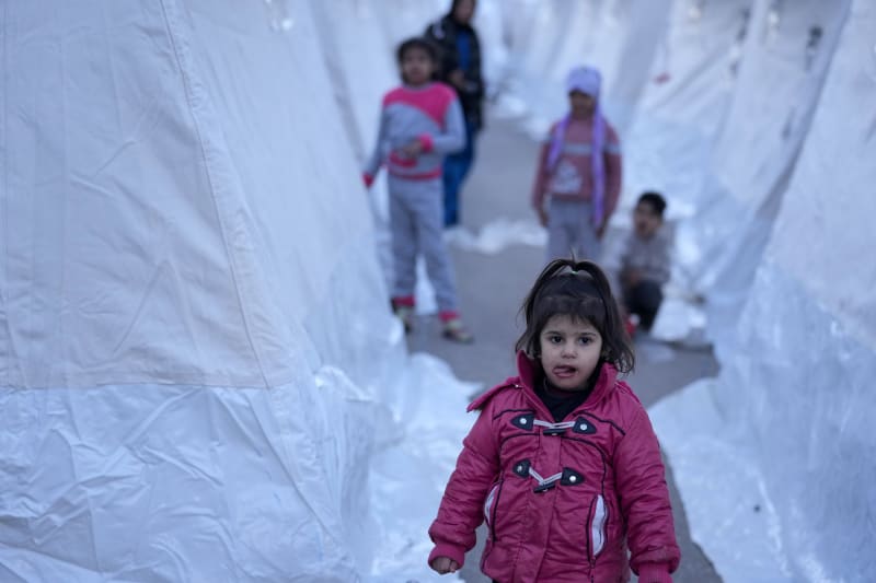 Děti procházejí mezi stany v Aslanli na jihovýchodě Turecka, čtvrtek 9. února 2023. 