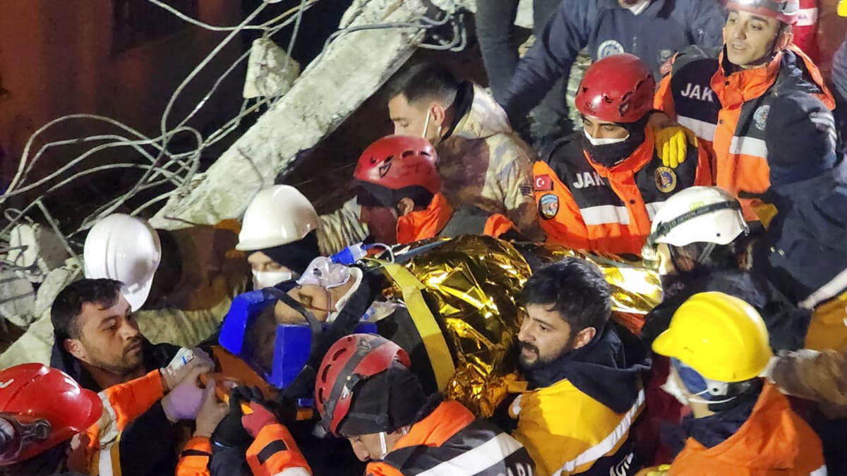 Záchranáři vytahují ženu ze zřícené budovy v Adiyamanu na jihu Turecka v pondělí 13. února 2023.