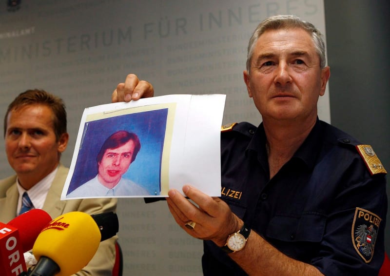Policista na tiskové konferenci drží portrét únosce Priklopila.