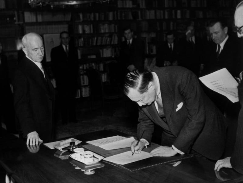 Edvard Beneš a Klement Gottwald přihlížejí podpisům členů nové vlády 27. února 1948 na Pražském hradě