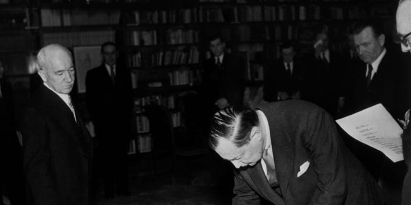 Edvard Beneš a Klement Gottwald přihlížejí podpisům členů nové vlády 27. února 1948 na Pražském hradě