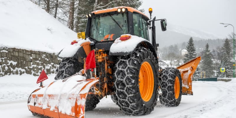 Traktor odklízí sníh ze silnice v centru Špindlerova Mlýna.