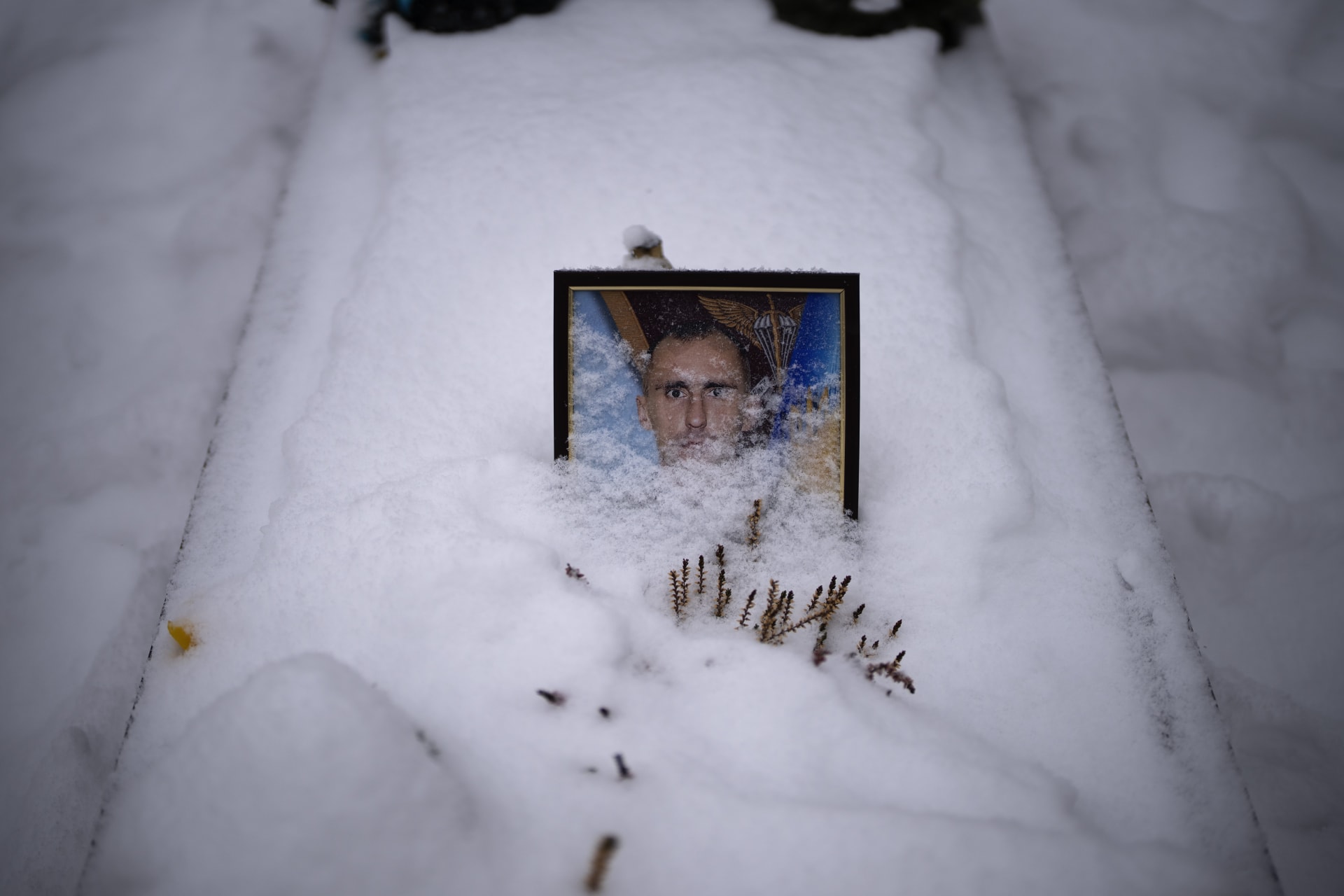 Portrét 42letého seržanta Mychajloviče Šchrmana, částečně zasypaný sněhem na jeho hrobě ve Lvově. Byl zabit 7. dubna 2022. (7.2.2023)