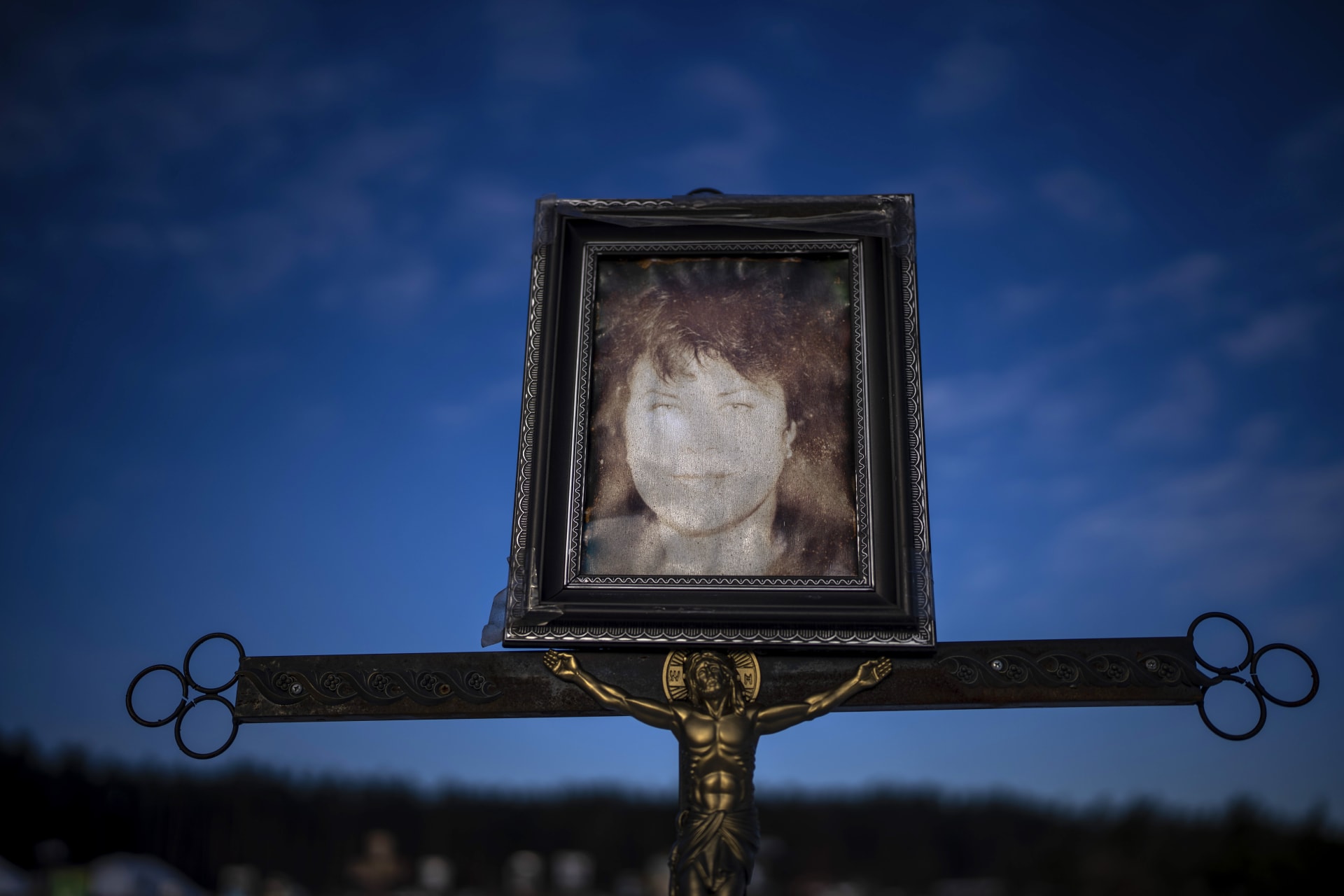 Vybledlý portrét 61leté Natalji Savlukové na jejím hrobě v Irpini. Savluková žila sama. Měla rakovinu v posledním stádiu, nikdo však nedokázal říct, jak zemřela. Ví se jediné – její život vyhasl za okupace. Pohřbena byla 3. března 2022. (10.3.2023)