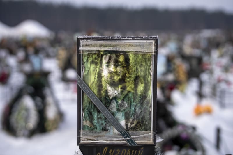 Poničený portrét 41letého Ivana Oleksandra Volodymyroviče na jeho hrobě Irpini. Byl zabit 5. března 2022. (9.2.2023)