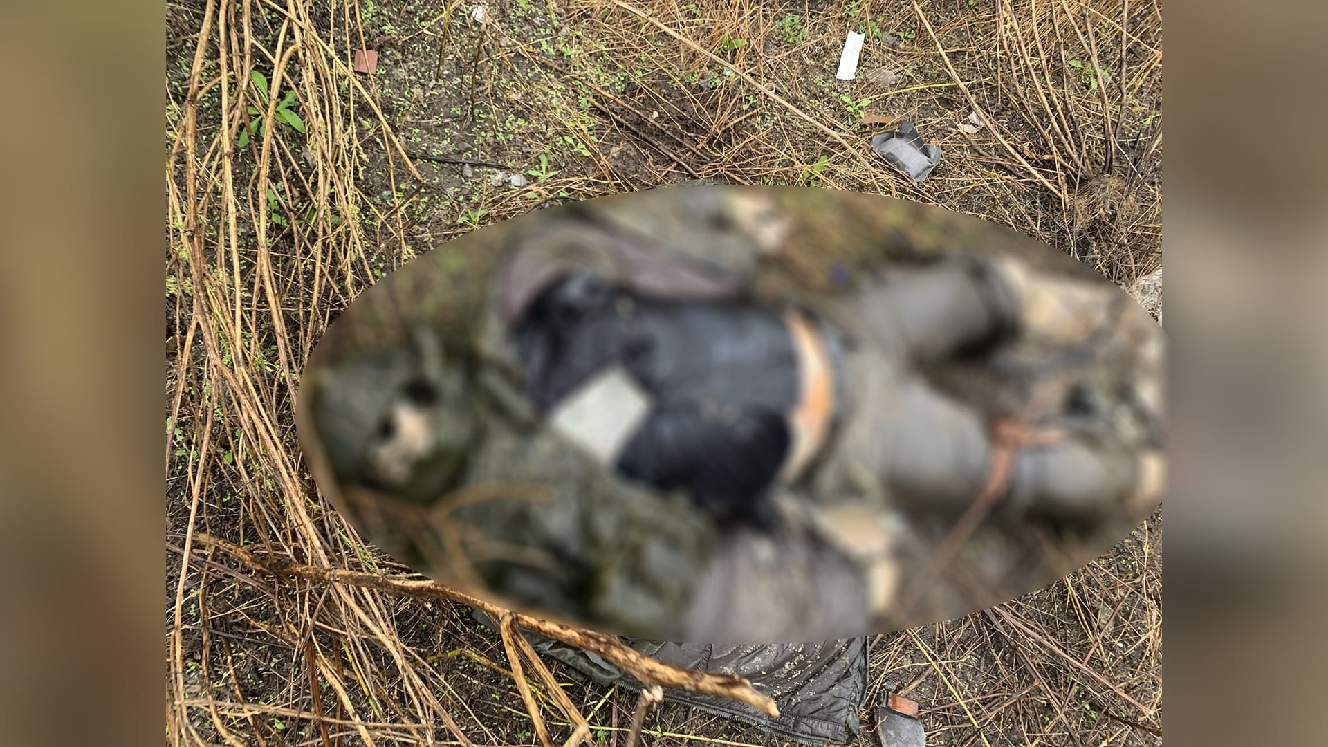 Tělo, které zůstalo v příkopu u cesty, po níž na Ukrajině postupovala ruská kolona. Obrázek ze záměrně rozostřen