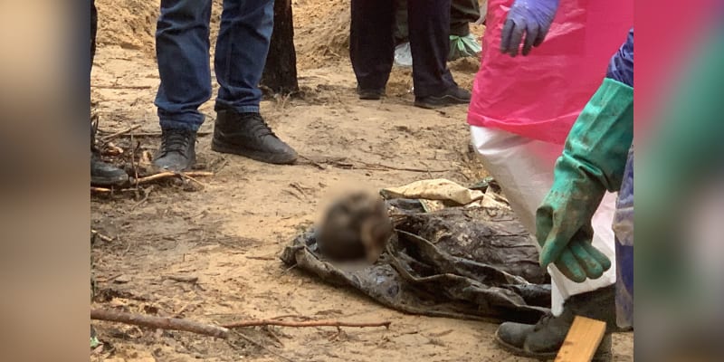 Tělo exhumované z hromadného hrobu v Izjumu. Obrázek je záměrně rozostřen.