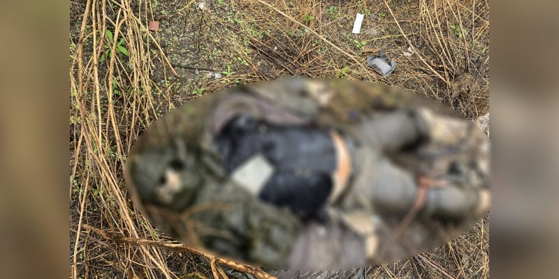 Tělo, které zůstalo v příkopu u cesty, po níž na Ukrajině postupovala ruská kolona. Obrázek ze záměrně rozostřen