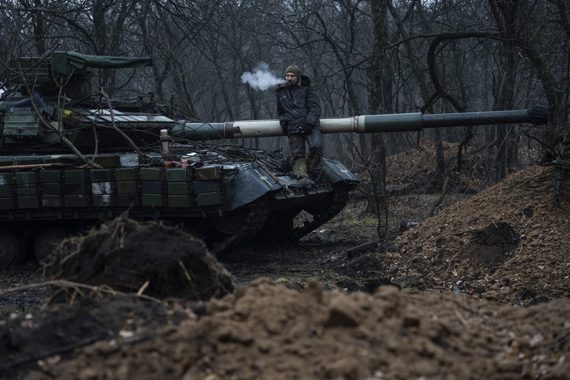 Ukrajinský voják kouří cigaretu sedíc přitom na tanku nedaleko frontové linie u Bachmutu