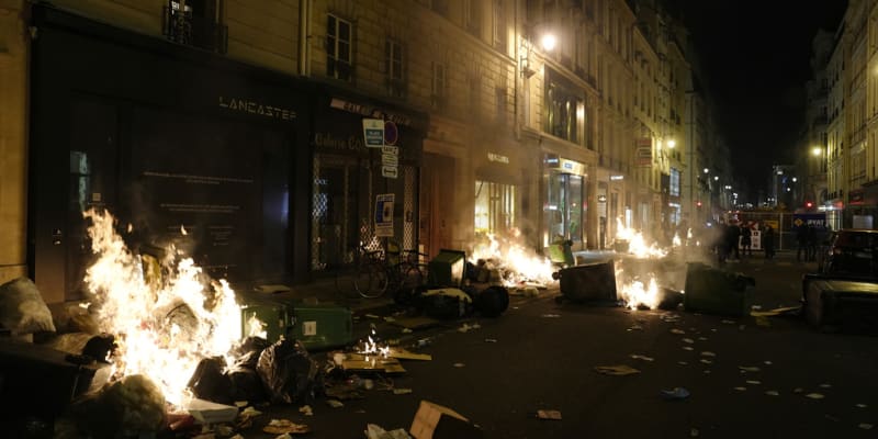 Odpadky zapálené demonstranty po demonstraci poblíž náměstí Concorde v Paříži, čtvrtek 16. března 2023.