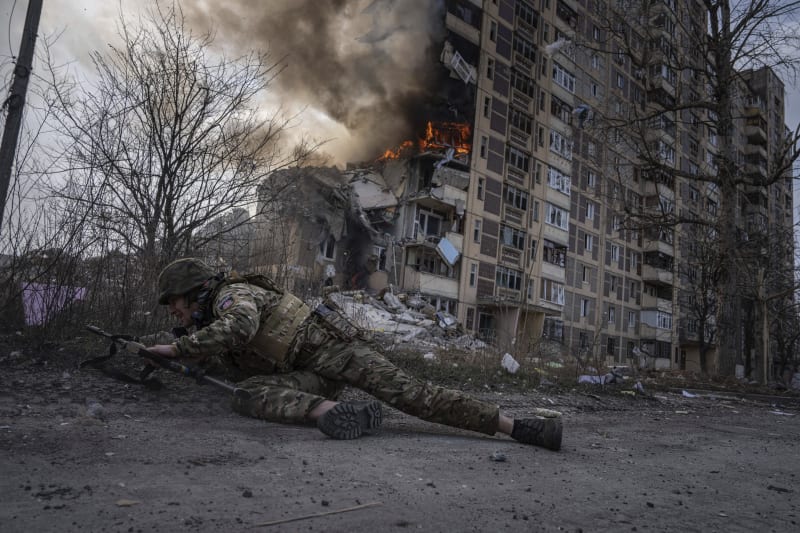 Ukrajinský voják se kryje v Avdijivce po ruském útoku (17. 3. 2023).