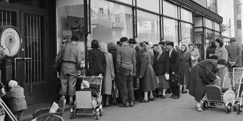 Rok 1953, těsně po měnové reformě. Lidé v Ostravě si prohlížejí zboží s novými cenami.