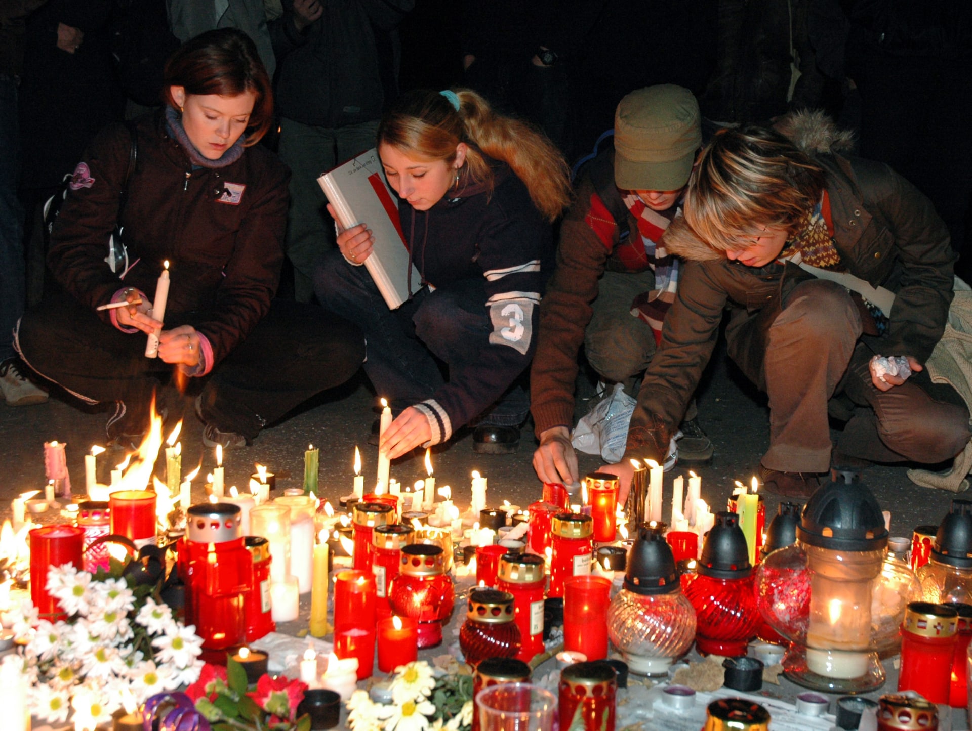 Lidé pokládají svíčky v místě vraždy Daniela Tupého, kam zamířil pochod  znlivosamířil pochod proti nesnášeti, rasismu a neonacismu (9. 11. 2005)