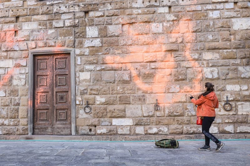 Aktivistka stříká oranžovou barvu na fasádu radnice Palazzo Vecchiofasádu 