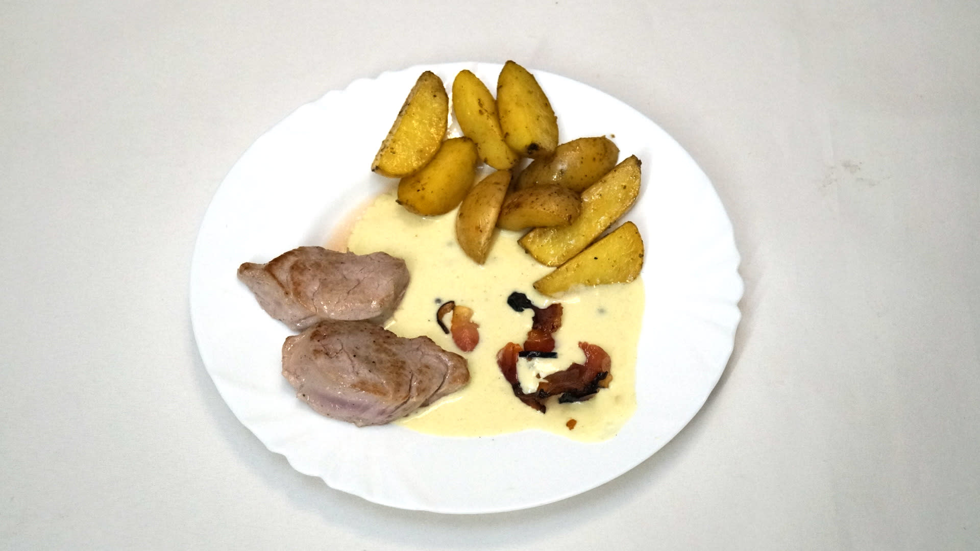 Vepřová panenka s pepřovou omáčkou, slaninové chipsy, pečené brambory