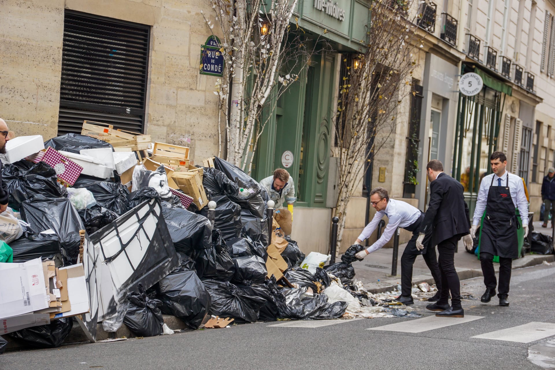Pařížské ulice zahlcené pytli s odpadem musel mnohdy čistit třeba personál blízkých restaurací, aby si k nim zákazníci vůbec našli cestu.