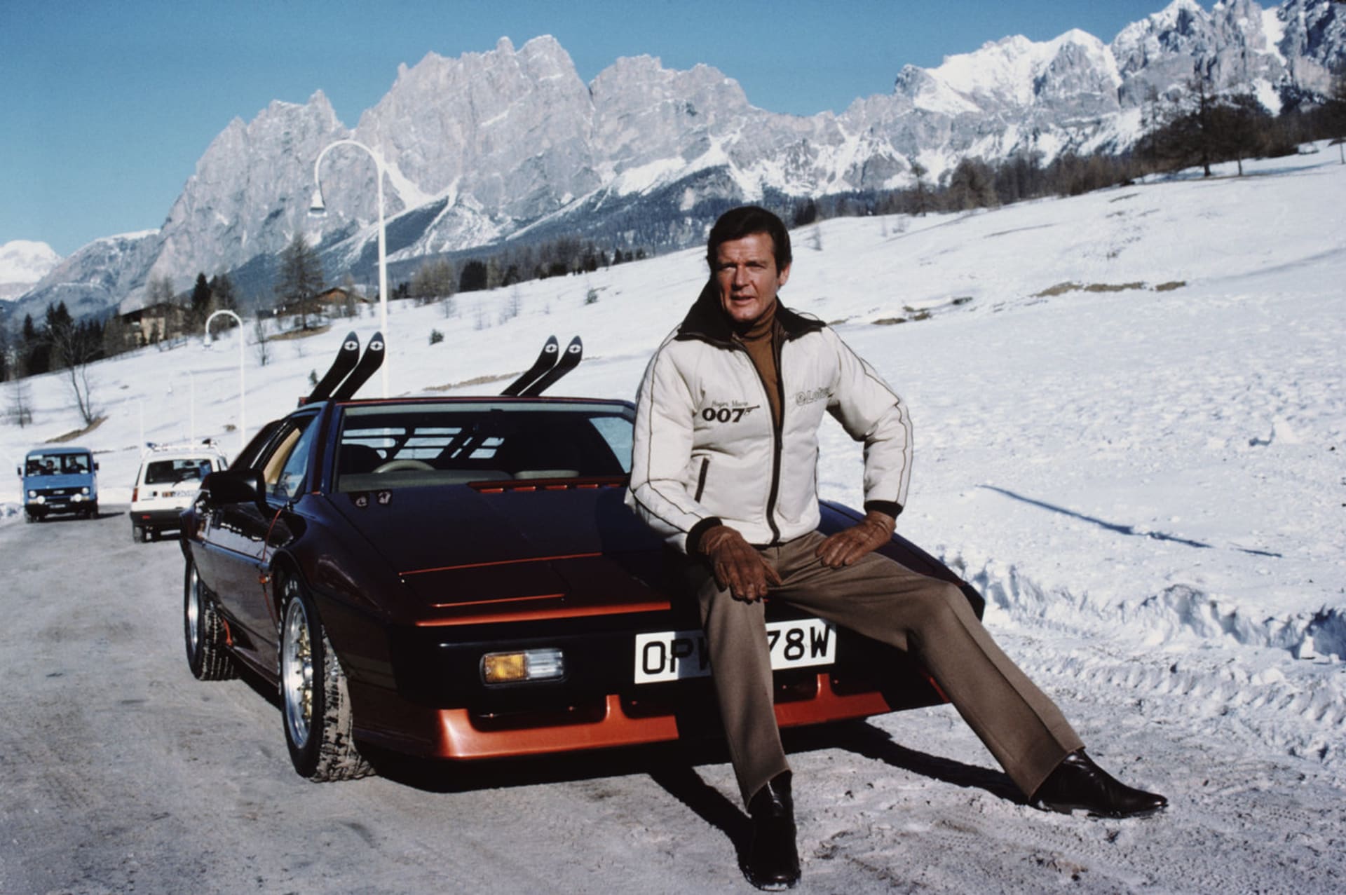 Anglický herec Roger Moore pózuje fotografovi při natáčení 007 s Lotusem Esprit Turbo (1981)