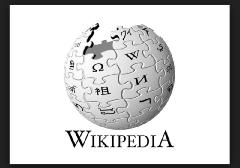 Každý kus skládačky symbolizuje piktogram a mnohojazyčnost Wikipedie. Pro sestavení názvu jsou použity znaky z různých písem. Volné místo nahoře znázorňuje její nedokončenou povahu - stále se přidávají nové jazyky, hesla a informace.