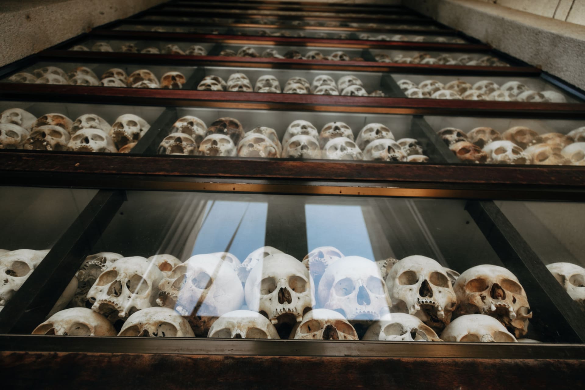 Tisíce lebek z masových hrobů genocidu dodnes přípomínají