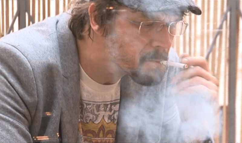 Zpěvák Dan Bárta zahalený v oblacích cigaretového dýmu